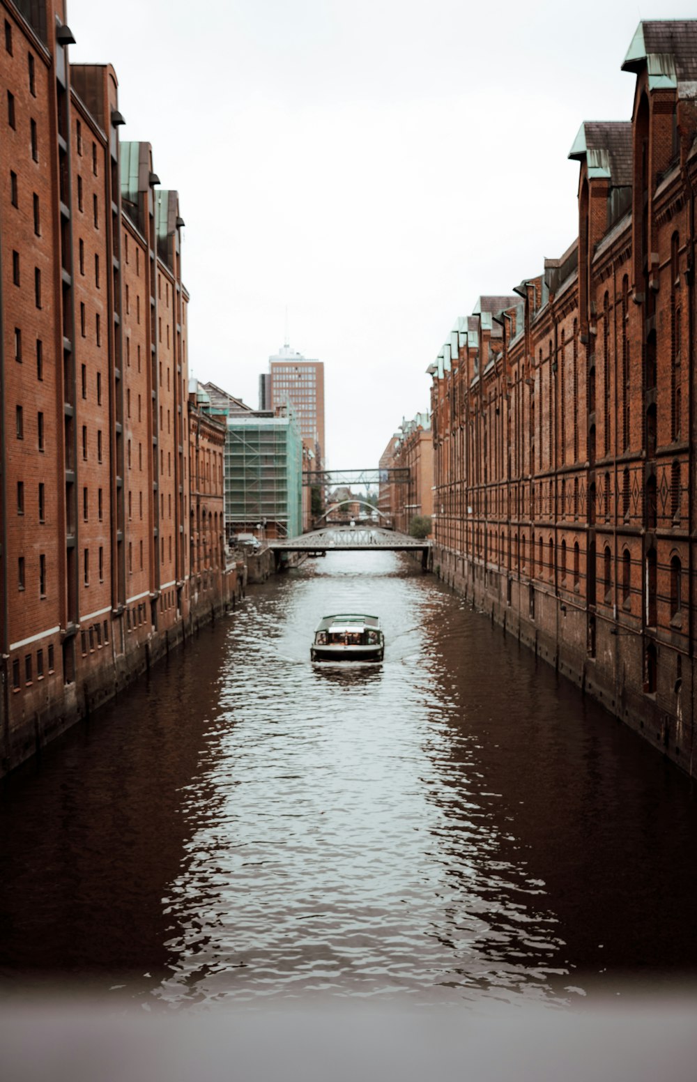 boat on river between buildings during daytime