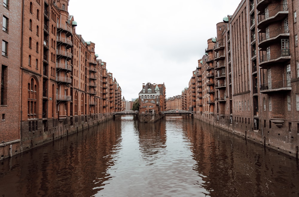 brown concrete building beside river during daytime