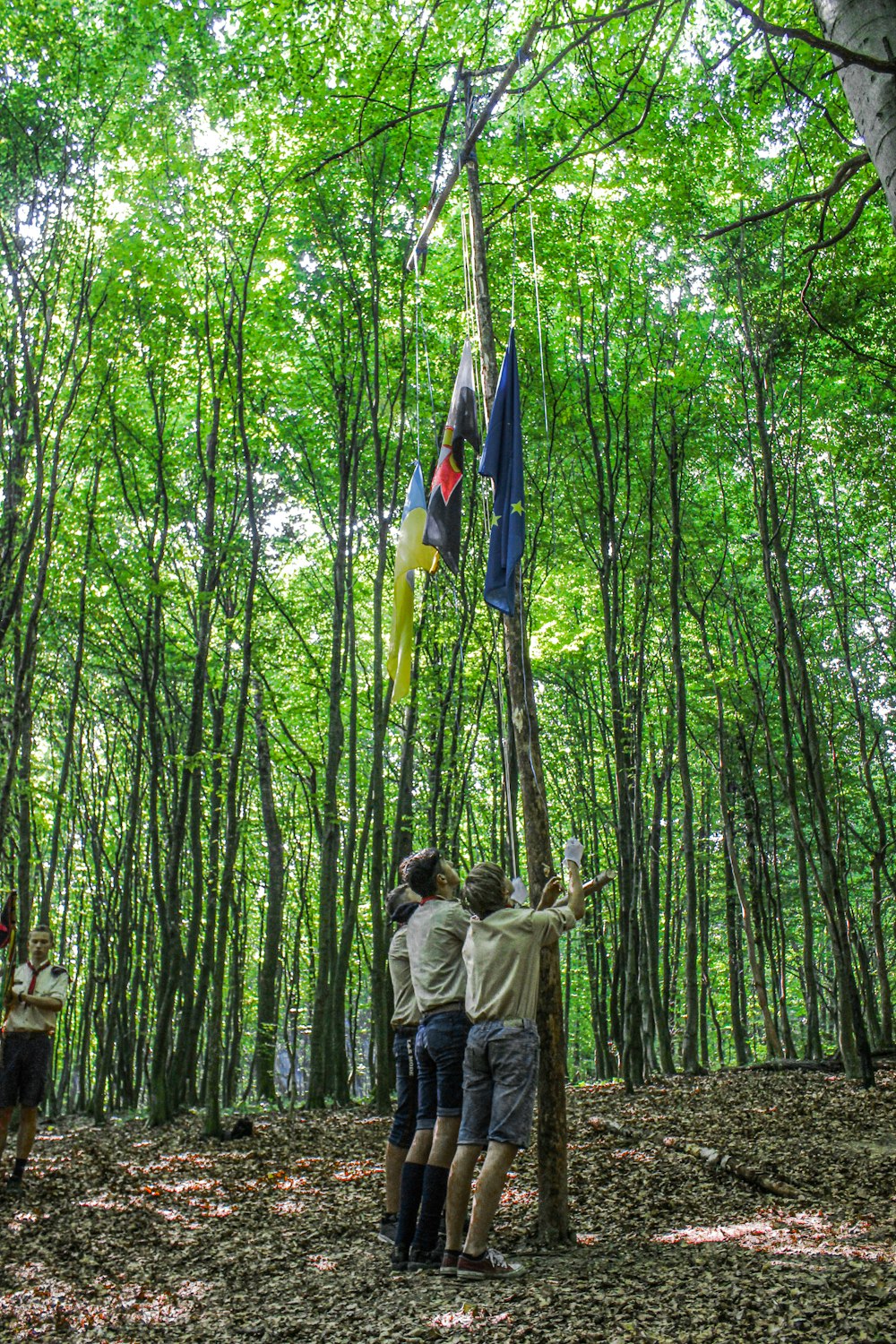 man in brown jacket and blue denim jeans standing on brown tree log