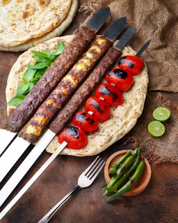 A colorful display of flame-grilled kebabs and koftas sizzling on the grill at Lime Tree Shawarma & Grill.