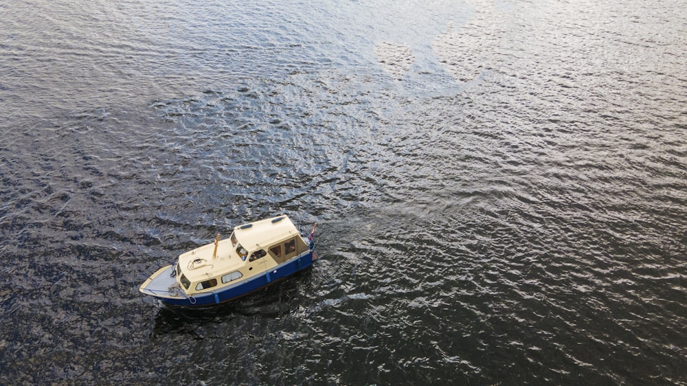 white and blue boat on body of water during daytime