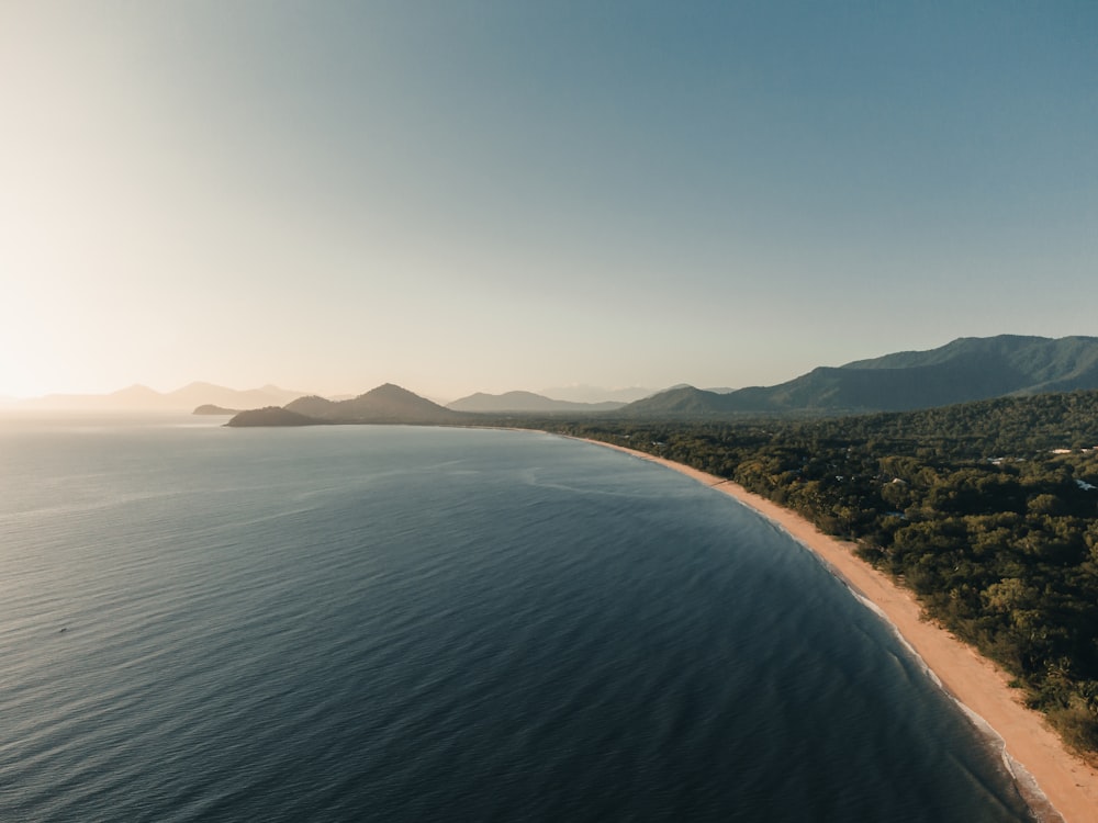 body of water near mountain during daytime