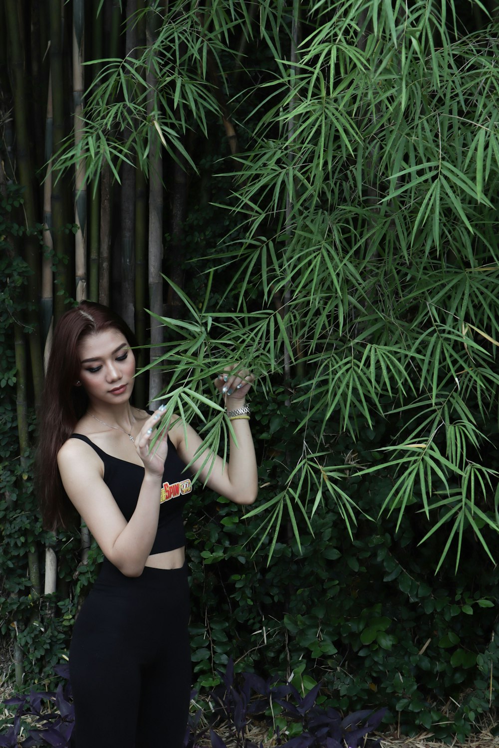 woman in black tank top holding green plant