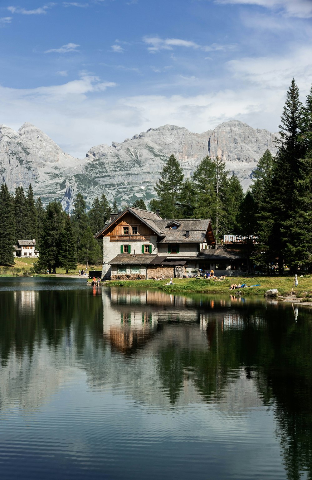 brown wooden house near lake and green trees during daytime