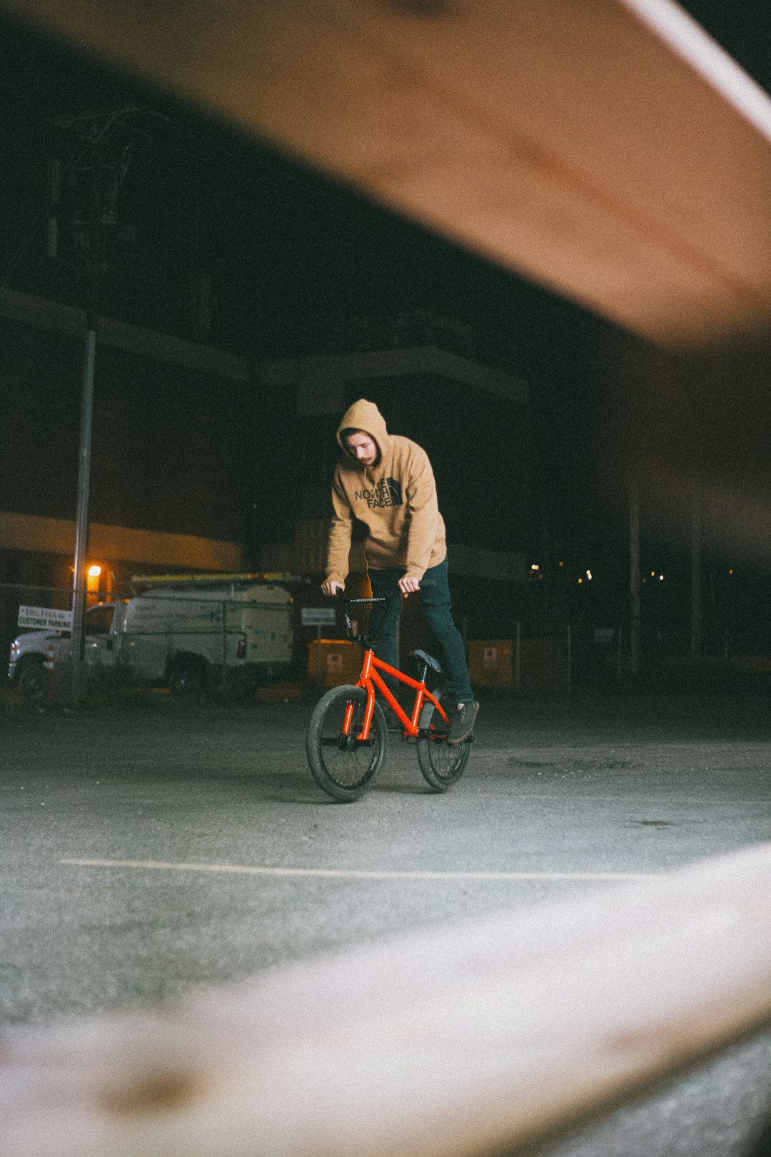 man in gray hoodie riding on bicycle during night time