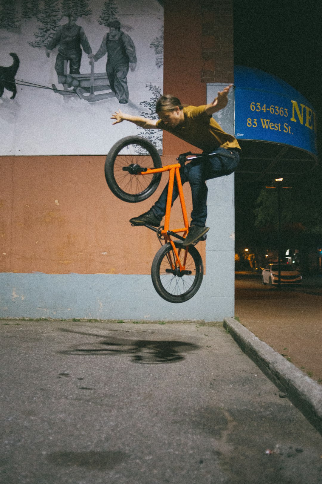 man in blue denim jeans and black jacket riding on bicycle