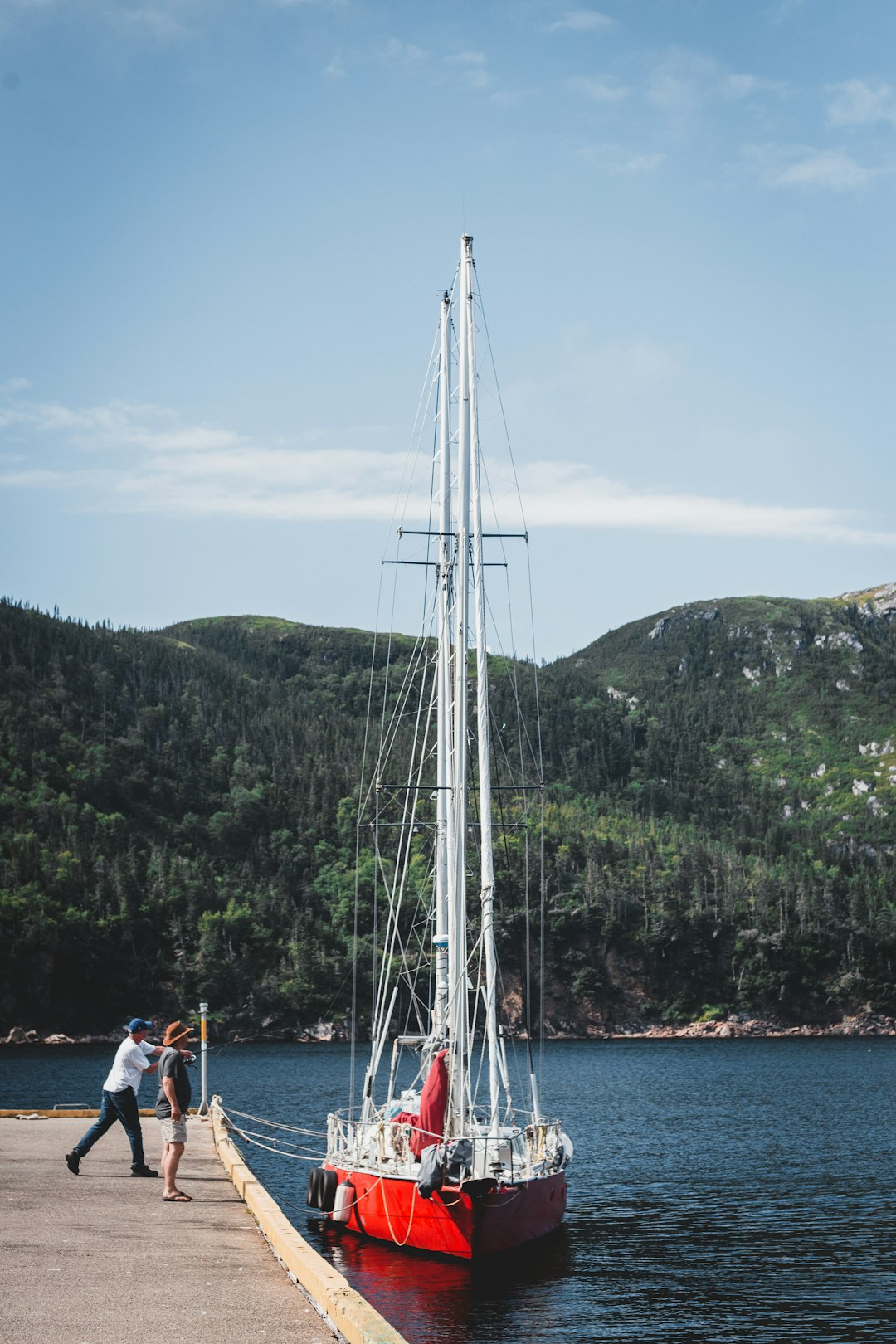 people on boat on sea near mountain during daytime