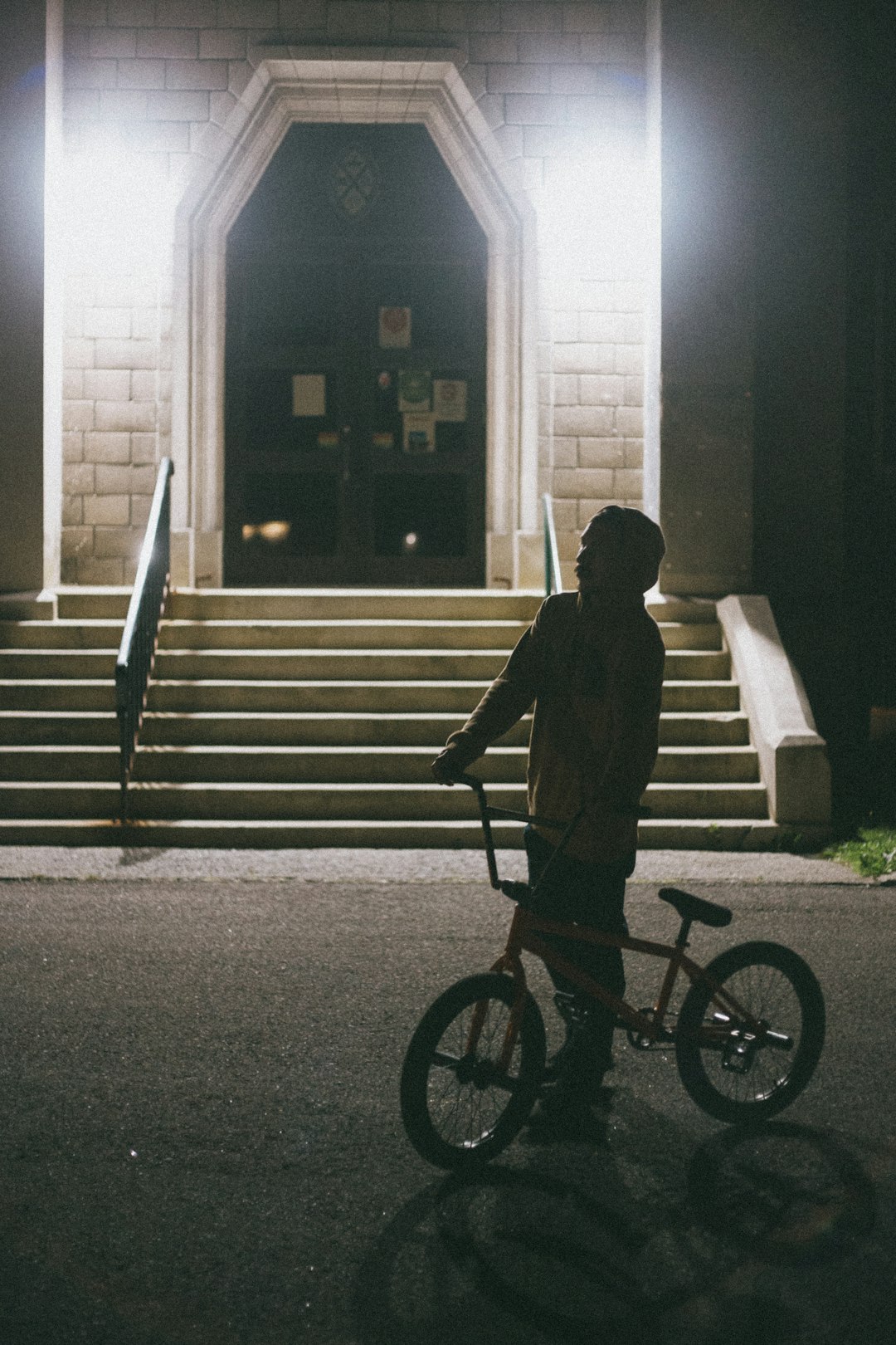 silhouette of man riding bicycle on road during daytime