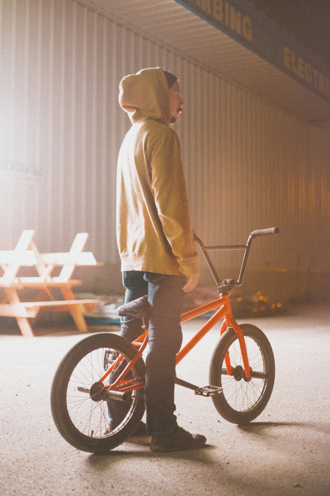 man in brown hoodie riding red bicycle during daytime
