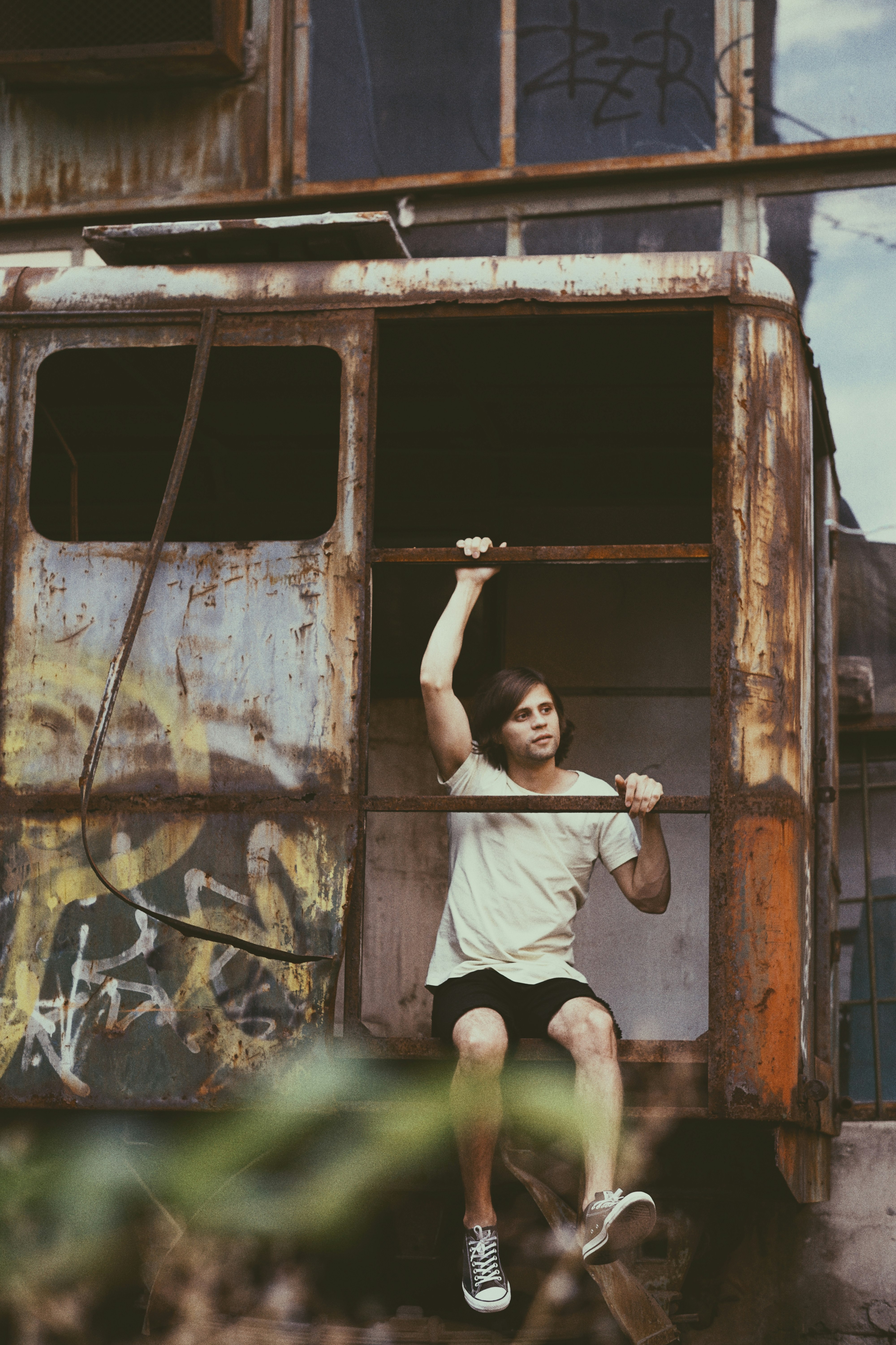 girl in white t-shirt and white shorts sitting on brown wooden swing during daytime