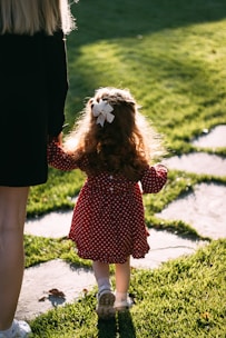 woman in black and red polka dot dress holding white bird