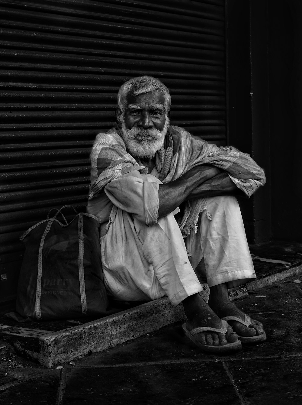 a black and white photo of a man sitting on a bench