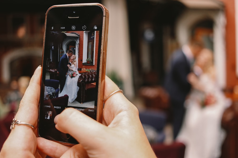 person holding iphone 6 with brown case