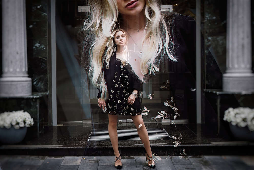 woman in black and white floral dress standing on brown brick floor