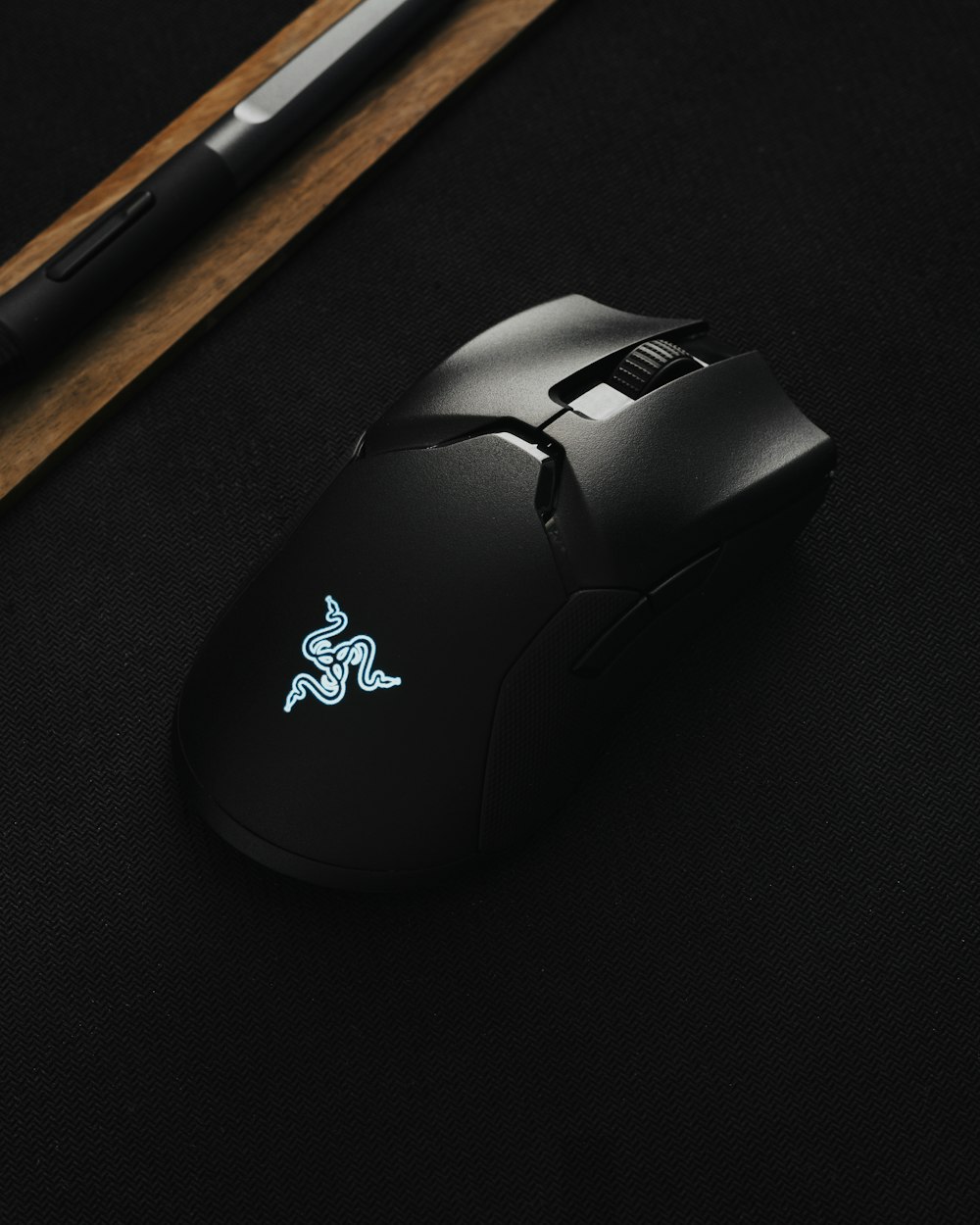 Ratón inalámbrico Logitech negro junto a lápiz de madera marrón