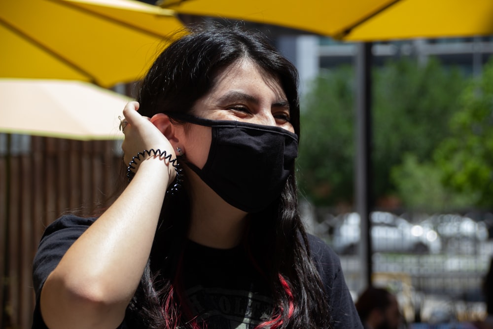 woman in black and red shirt wearing black mask