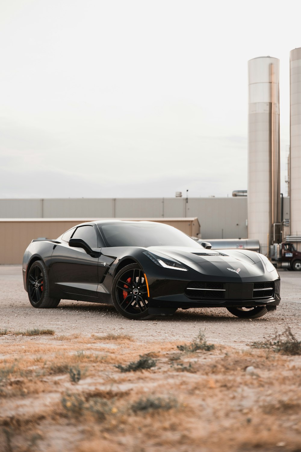 black coupe parked on brown field during daytime