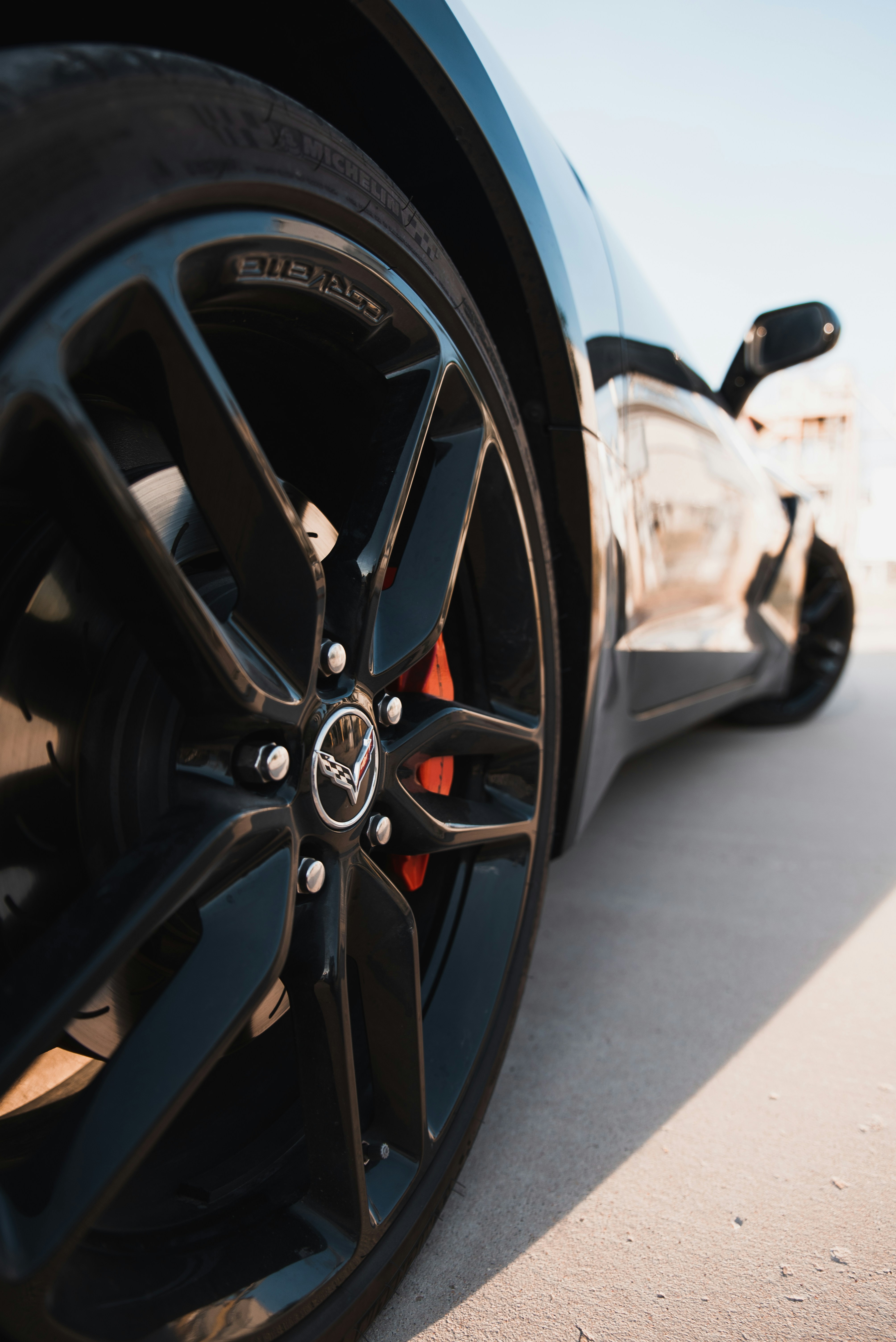 Close up of a sim racing steering wheel with a driver wearing gloves, focused on the controls.