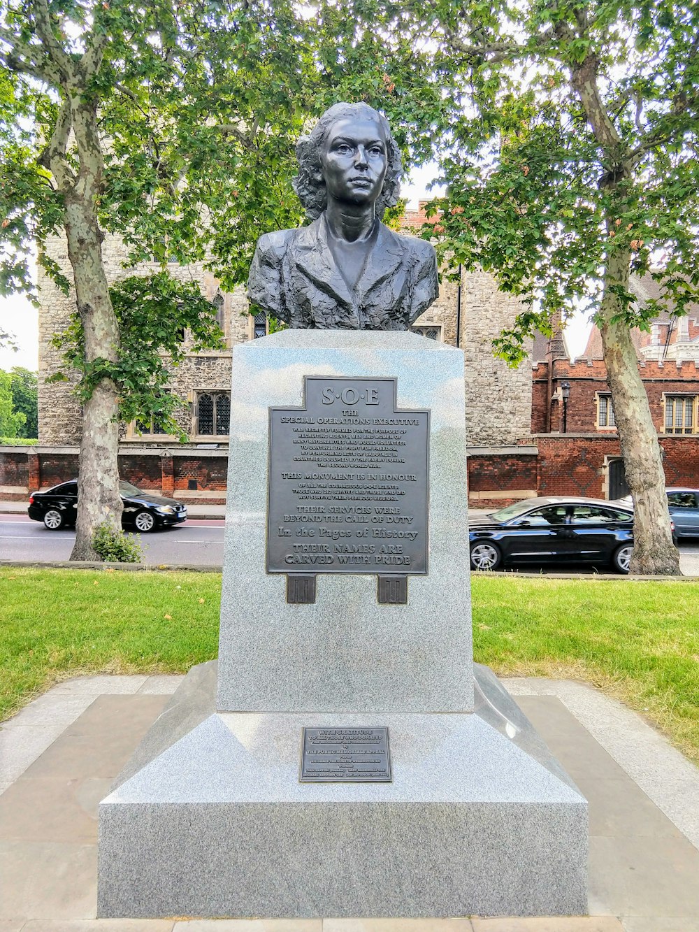 gray concrete statue near green trees during daytime