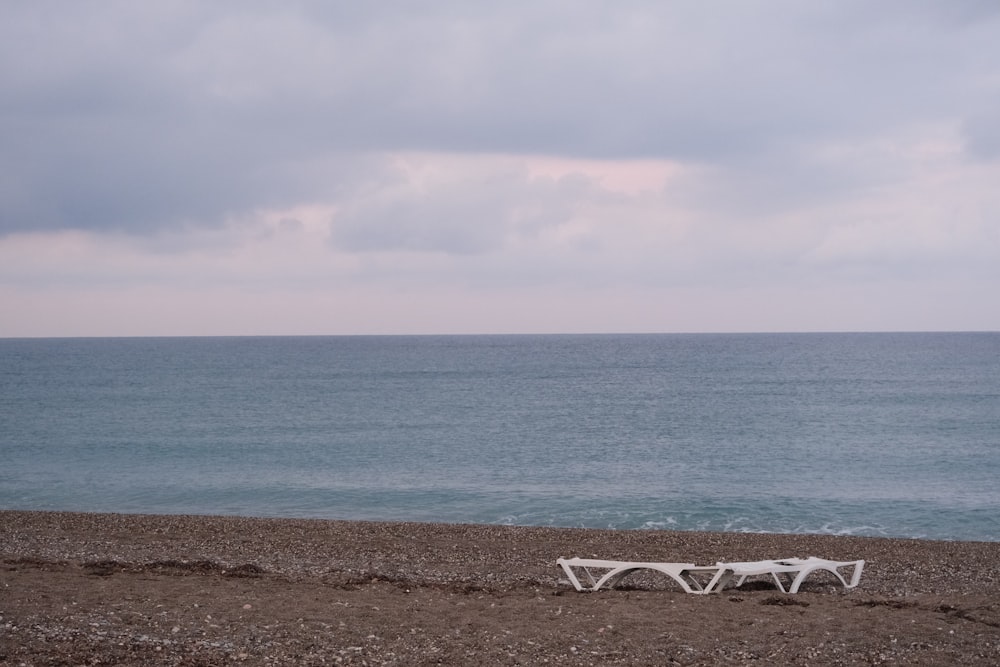 sillón de plástico blanco en la playa durante el día