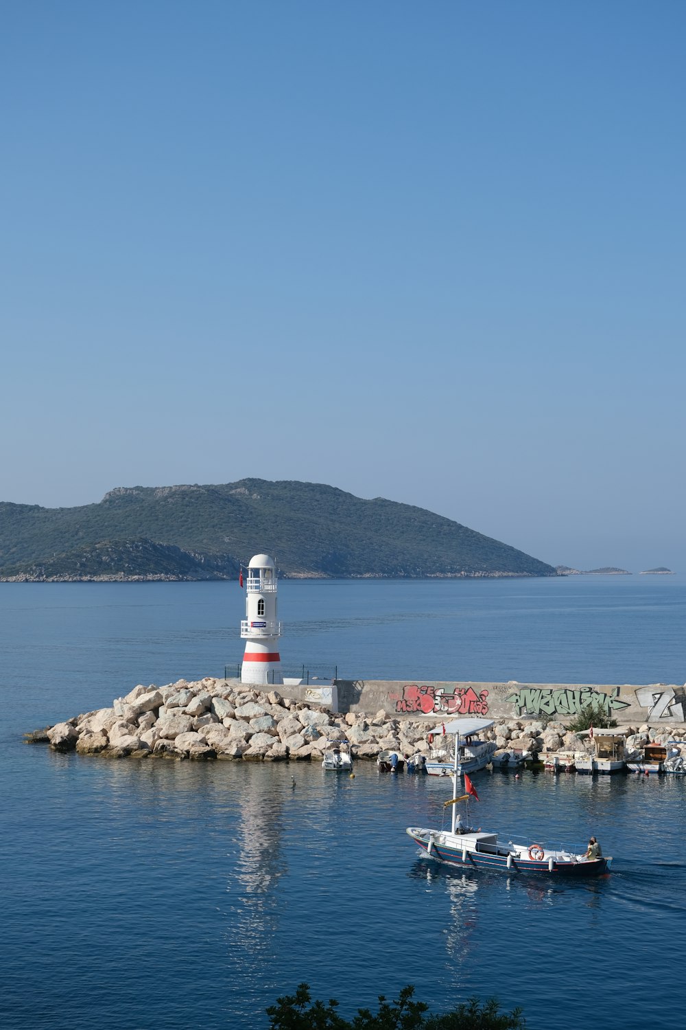 white and red lighthouse near body of water during daytime