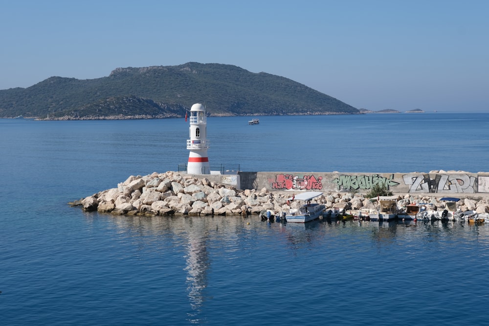 white and red lighthouse near body of water during daytime