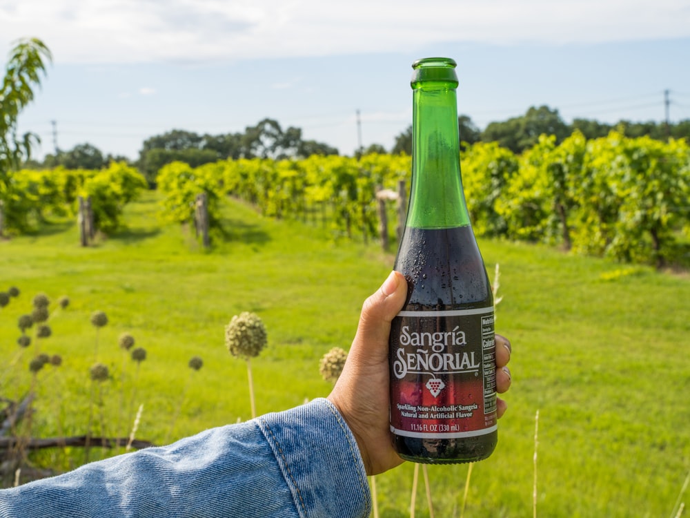 person holding black labeled bottle