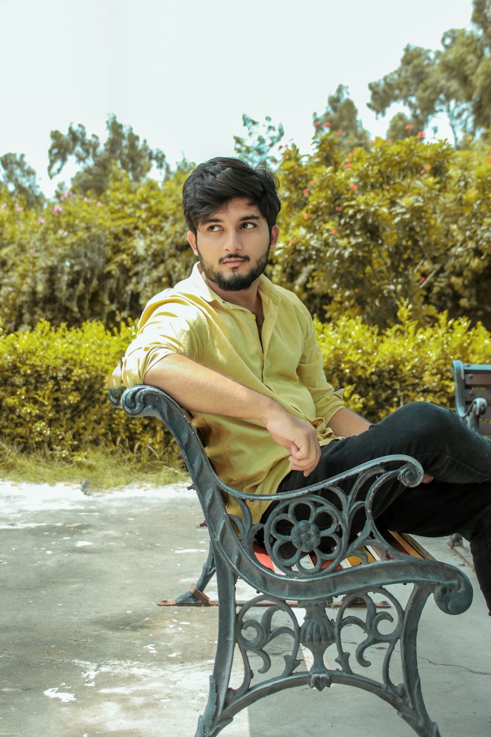 man in yellow polo shirt sitting on black metal chair