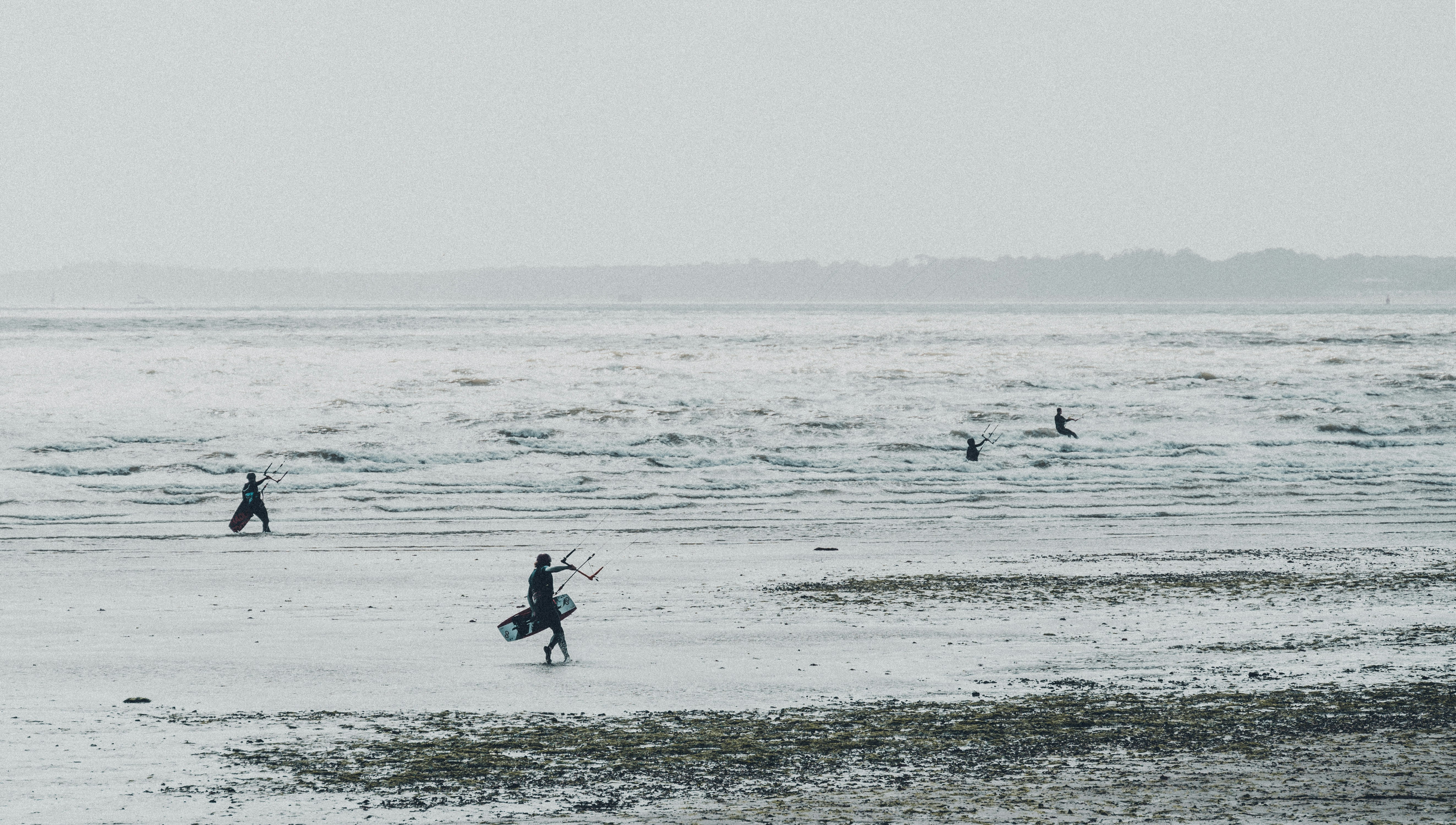 2 personnes tenant une planche de surf sur la mer pendant la journée