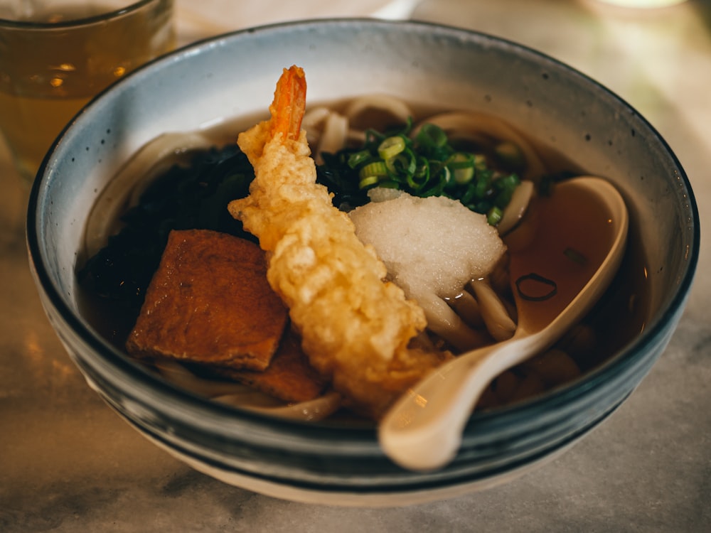 brown soup with white rice on stainless steel bowl