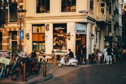 people sitting on bench in front of store during daytime