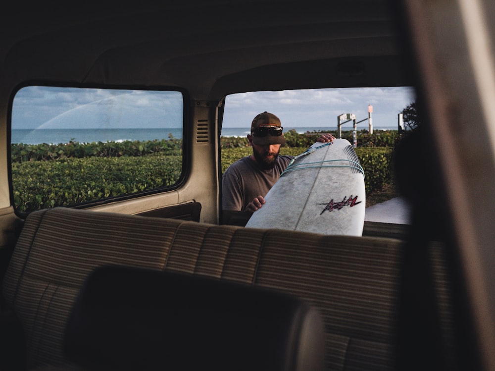 man in white shirt sitting on car seat