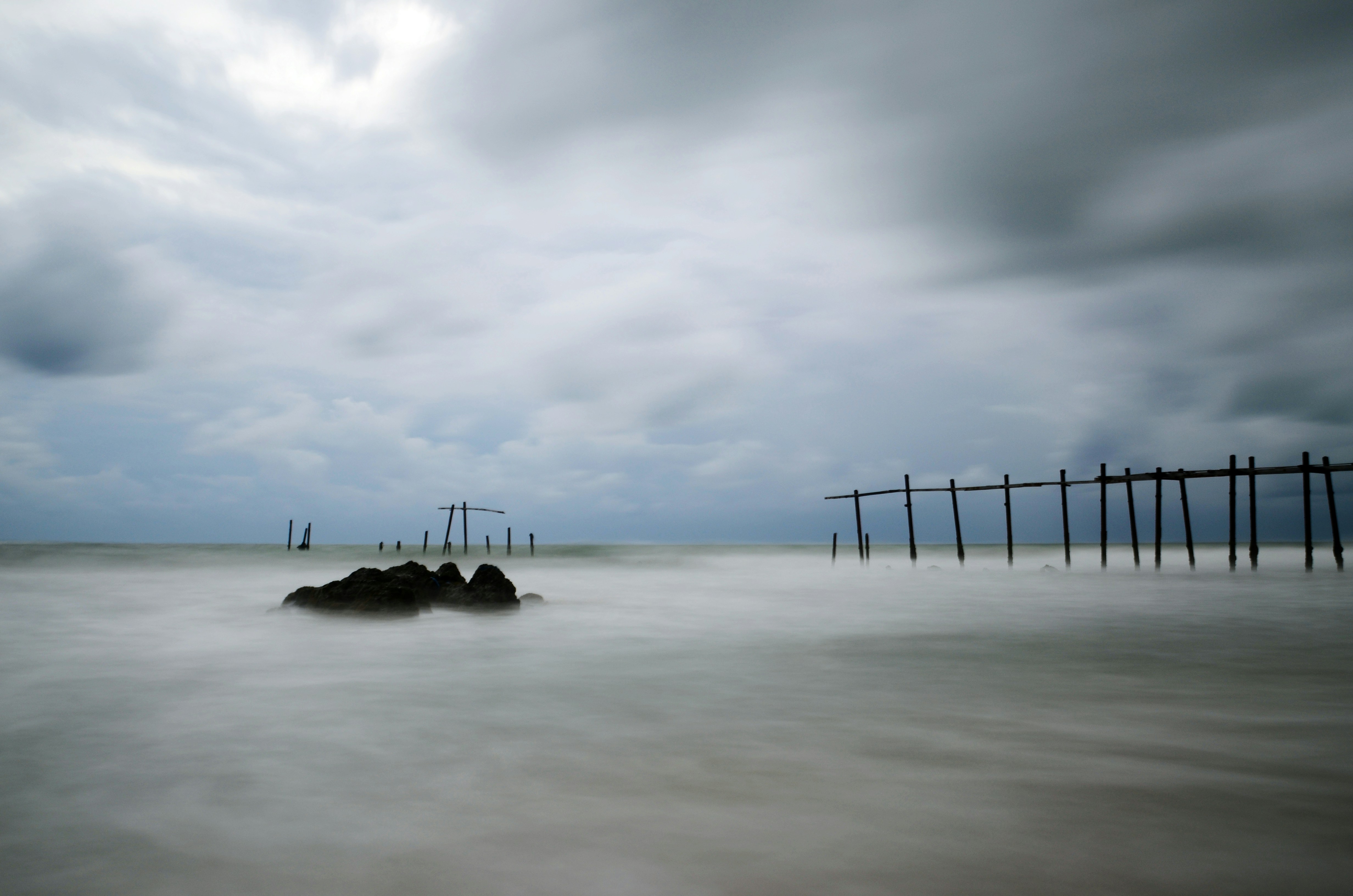 Wooden structures on a stormy beach with blurred water