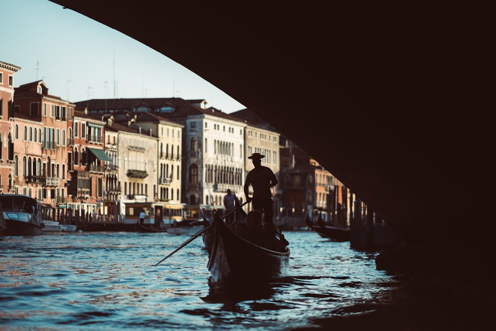 Hombre en chaqueta negra montando bote en el río durante el día