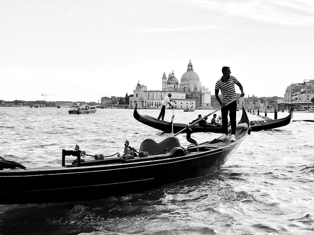 man in black and white striped shirt riding on boat on body of water