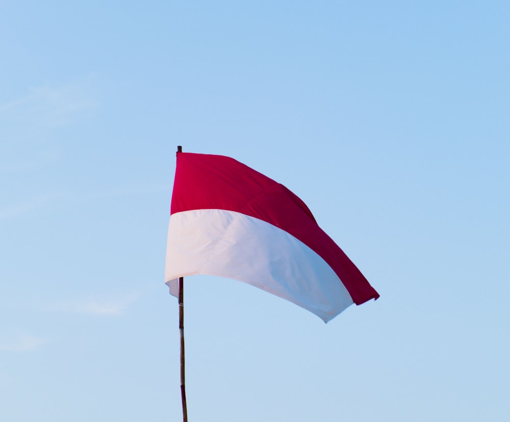red and white flag on pole during daytime