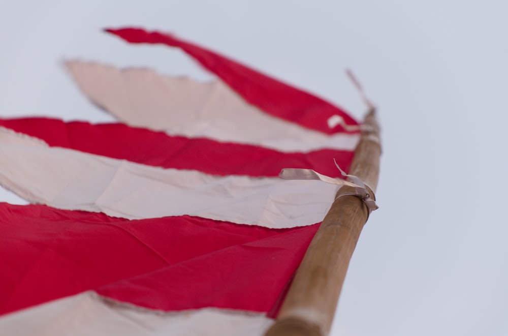 red and white flag on brown wooden pole
