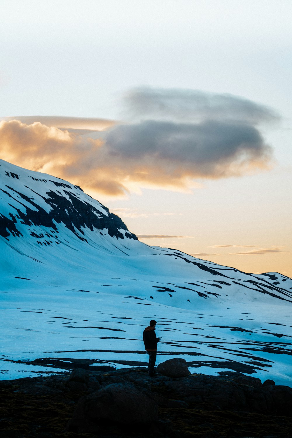 person standing on snow covered mountain during daytime