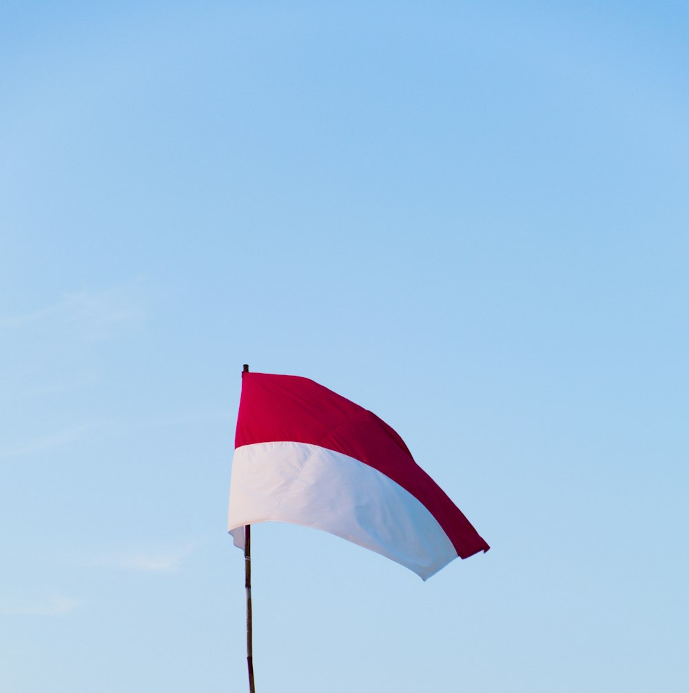 red and white flag on pole during daytime