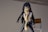 A figurine of an anime character with long black hair and a contemplative expression sits on a chair. The character is wearing a school uniform consisting of a white shirt and dark-colored skirt. The background is neutral, drawing focus to the figurine.