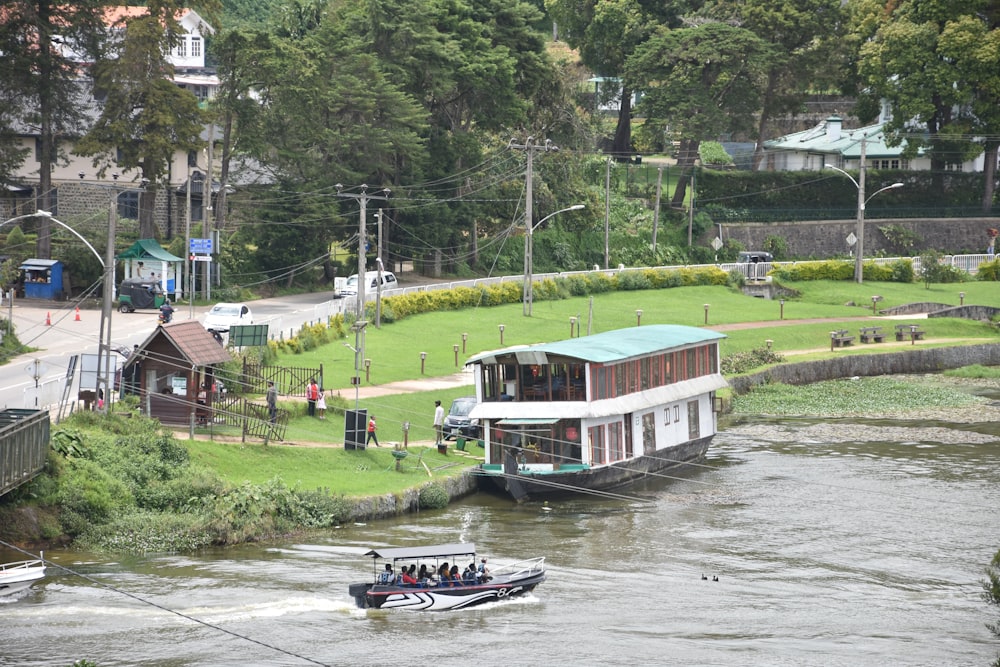 white and blue boat on river near green grass field during daytime