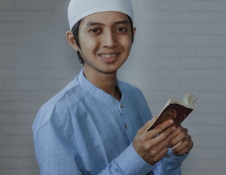 man in blue dress shirt holding brown smartphone