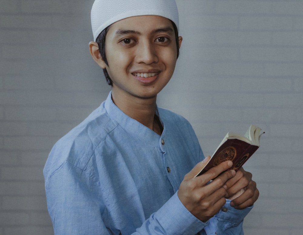 man in blue dress shirt holding brown smartphone