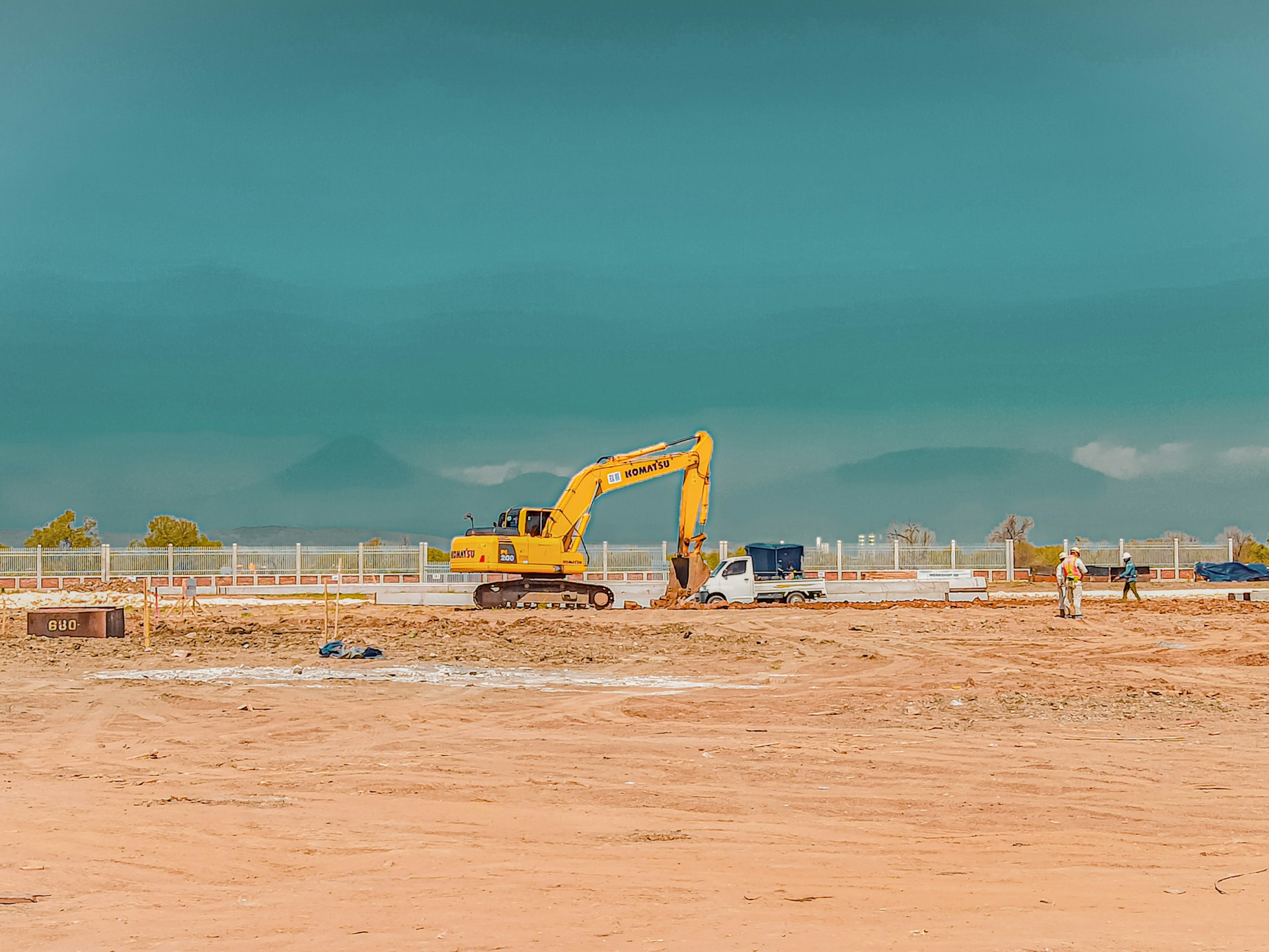 yellow excavator on brown sand under blue sky during daytime