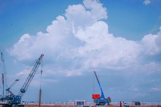red and white crane under blue sky during daytime