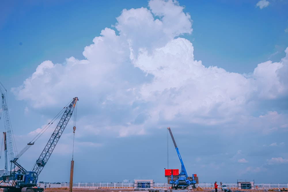 red and white crane under blue sky during daytime