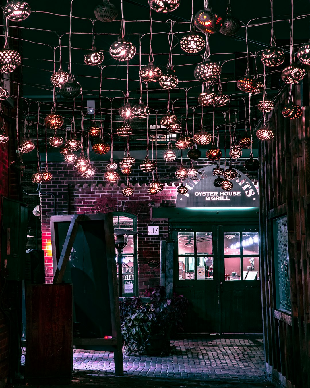 green and white wooden house with string lights