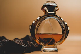clear glass perfume bottle on black and white textile