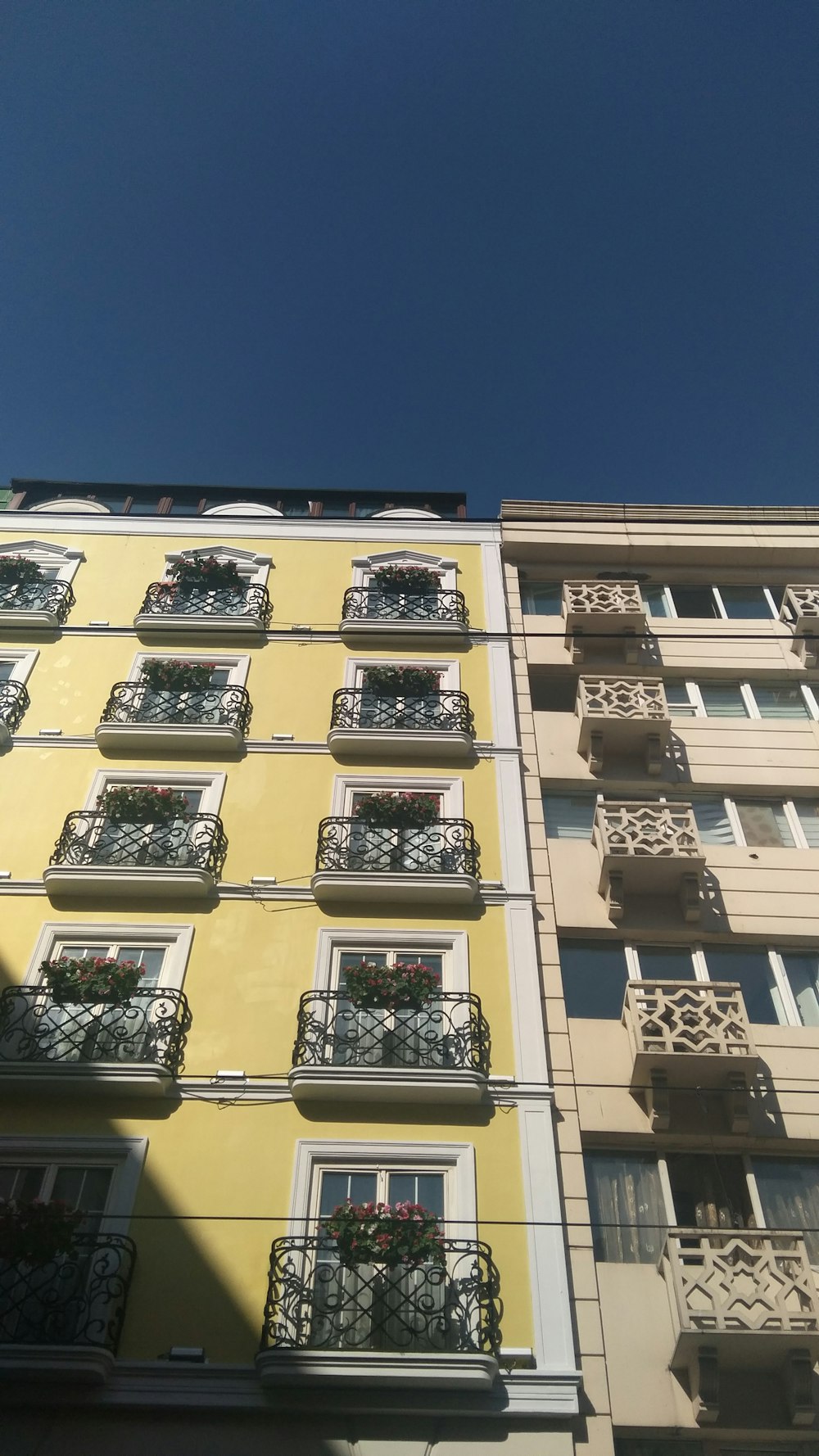 beige concrete building with black metal window grill