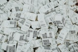 A large number of white cartons with black text saying 'Boxed Water is Better' are piled together. The cartons have graphics and text promoting sustainability.